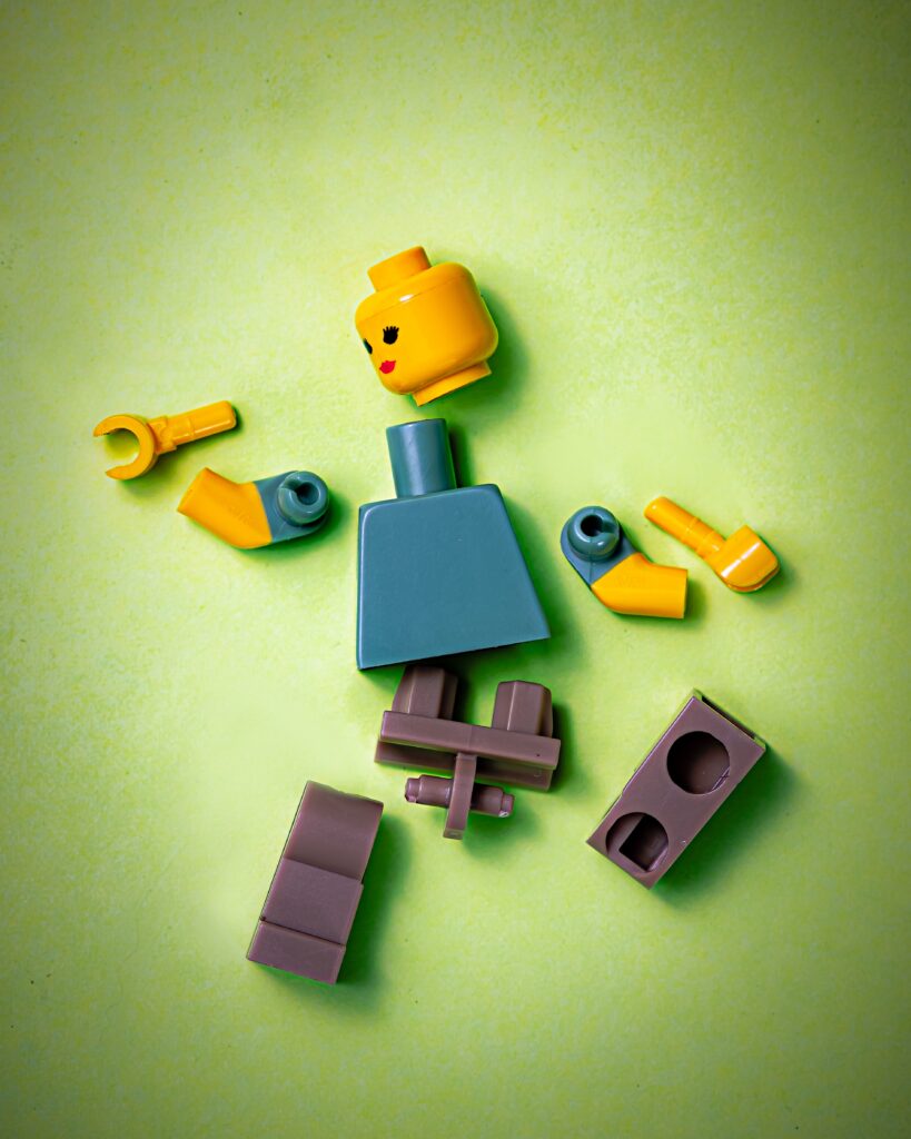 A plastic lego character lies in pieces