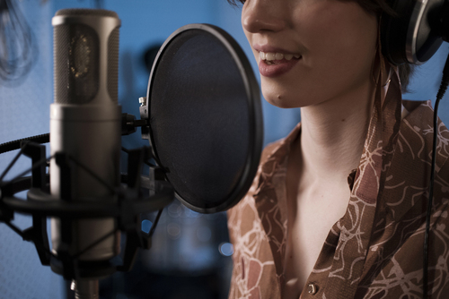 Woman recording a voice-over in a studio